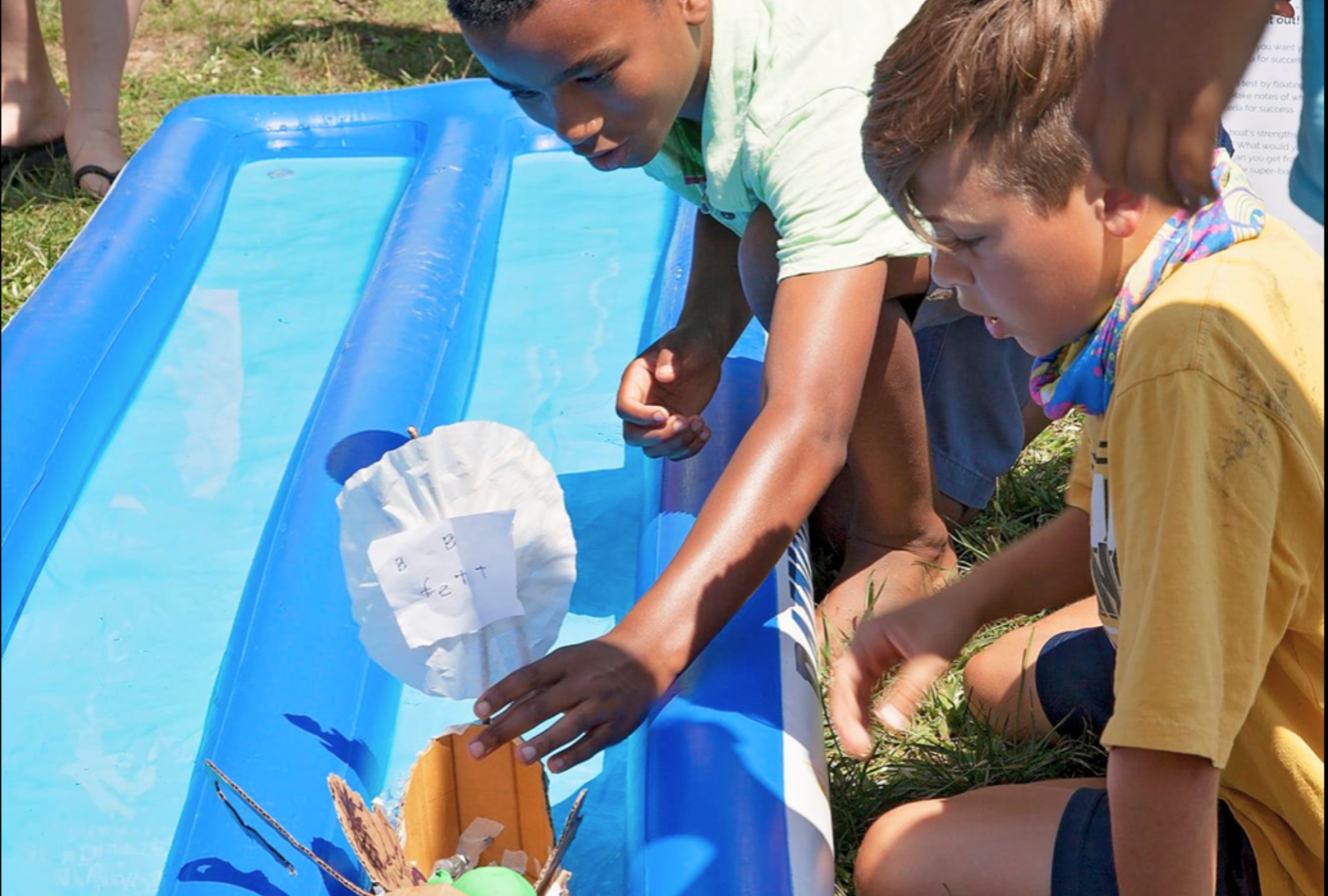 Boys test the toy boat they build through a STEM experiment