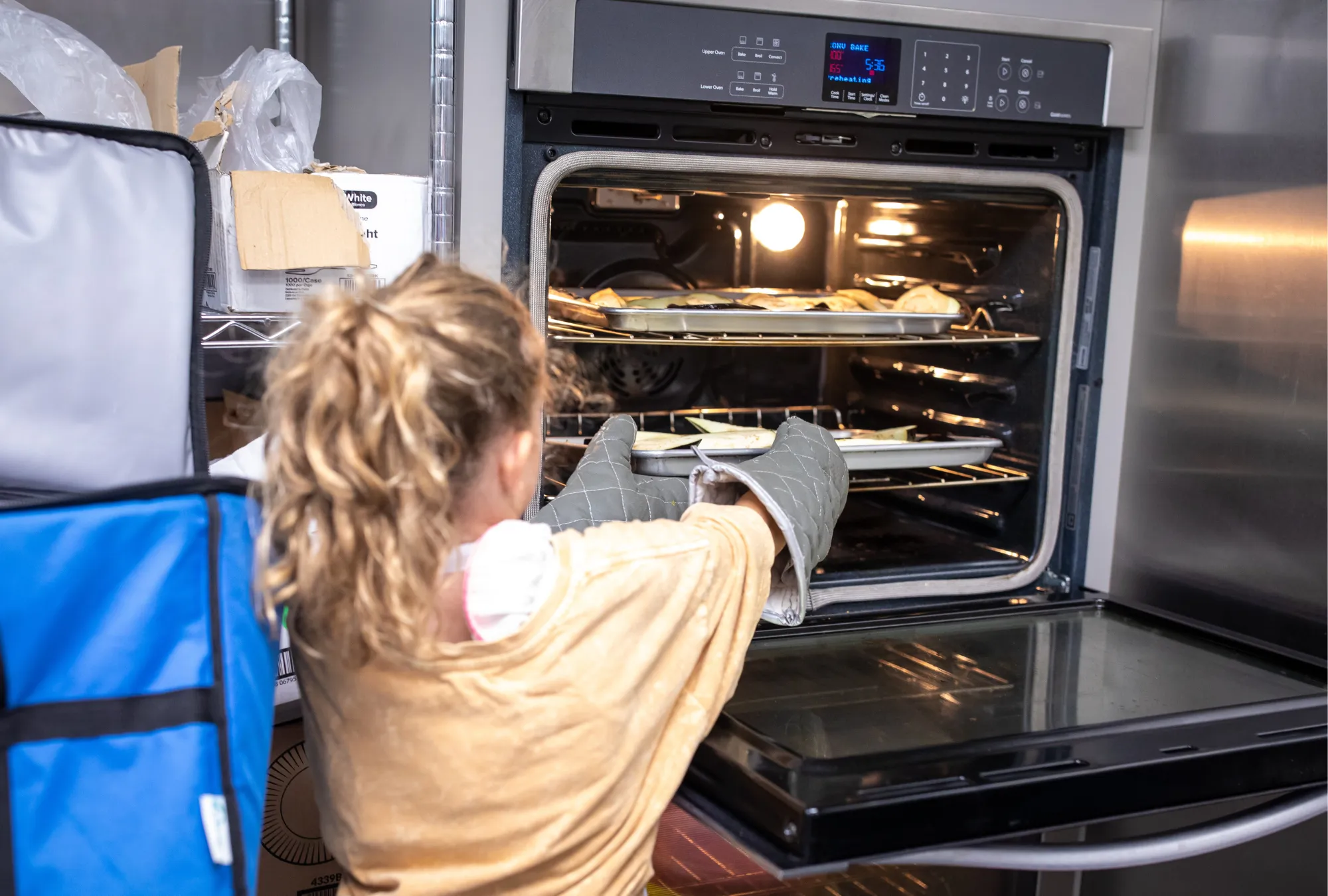 girl putting food in oven