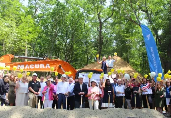 A large group of elected officials and metrowest residents pose at the construction site.
