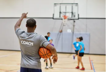 Coach directing players in the MetroWest YMCA Youth Basketball league