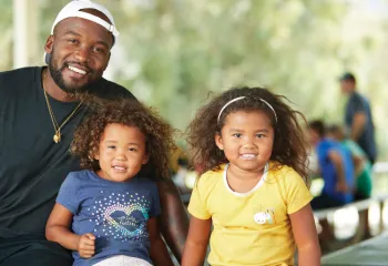 image of a dad with two young girls