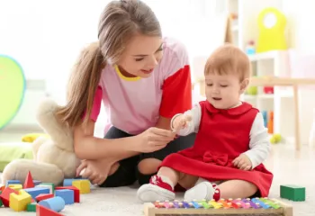 image of teenage girl babysitting young toddler