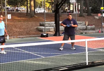 image of two adults playing outdoor pickleball