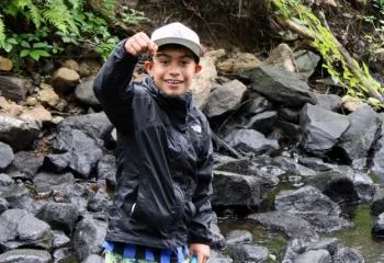 boy holding up a crayfish