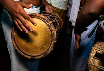 Action shot of someone playing the talking drum