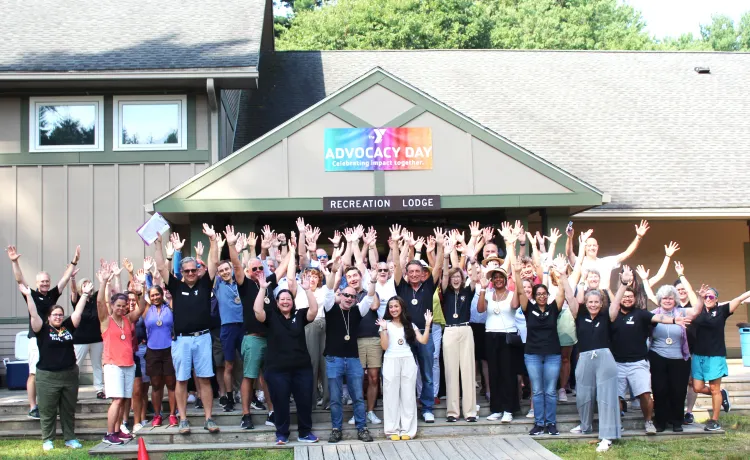 large group of people posing for photo with their arms in the air