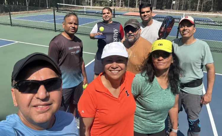 selfie of a group of pickleball players standing on an outdoor court