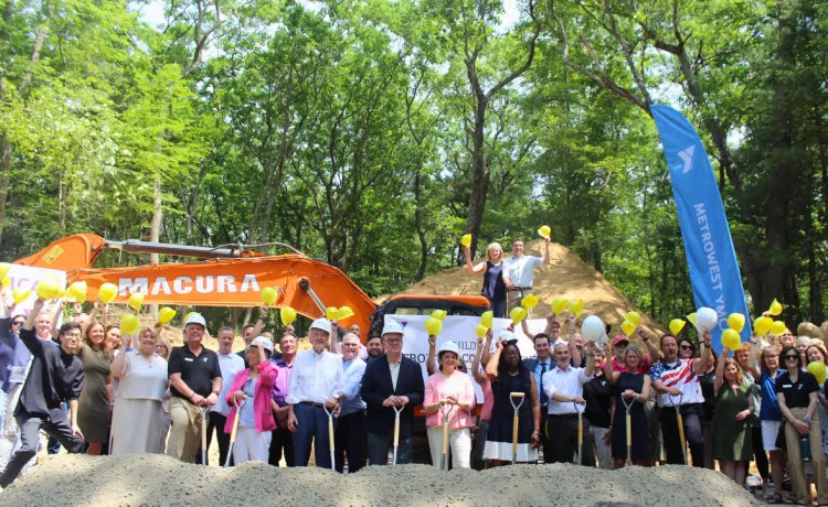A large group of elected officials and metrowest residents pose at the construction site.