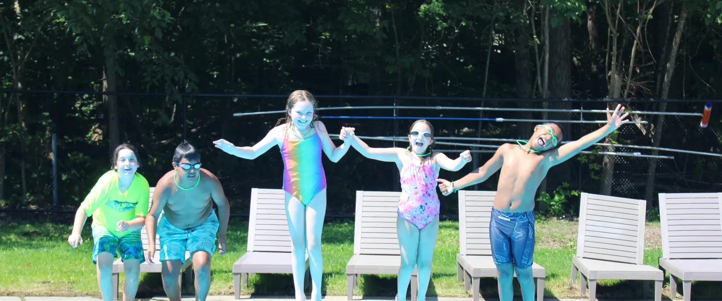 campers jumping into the pool