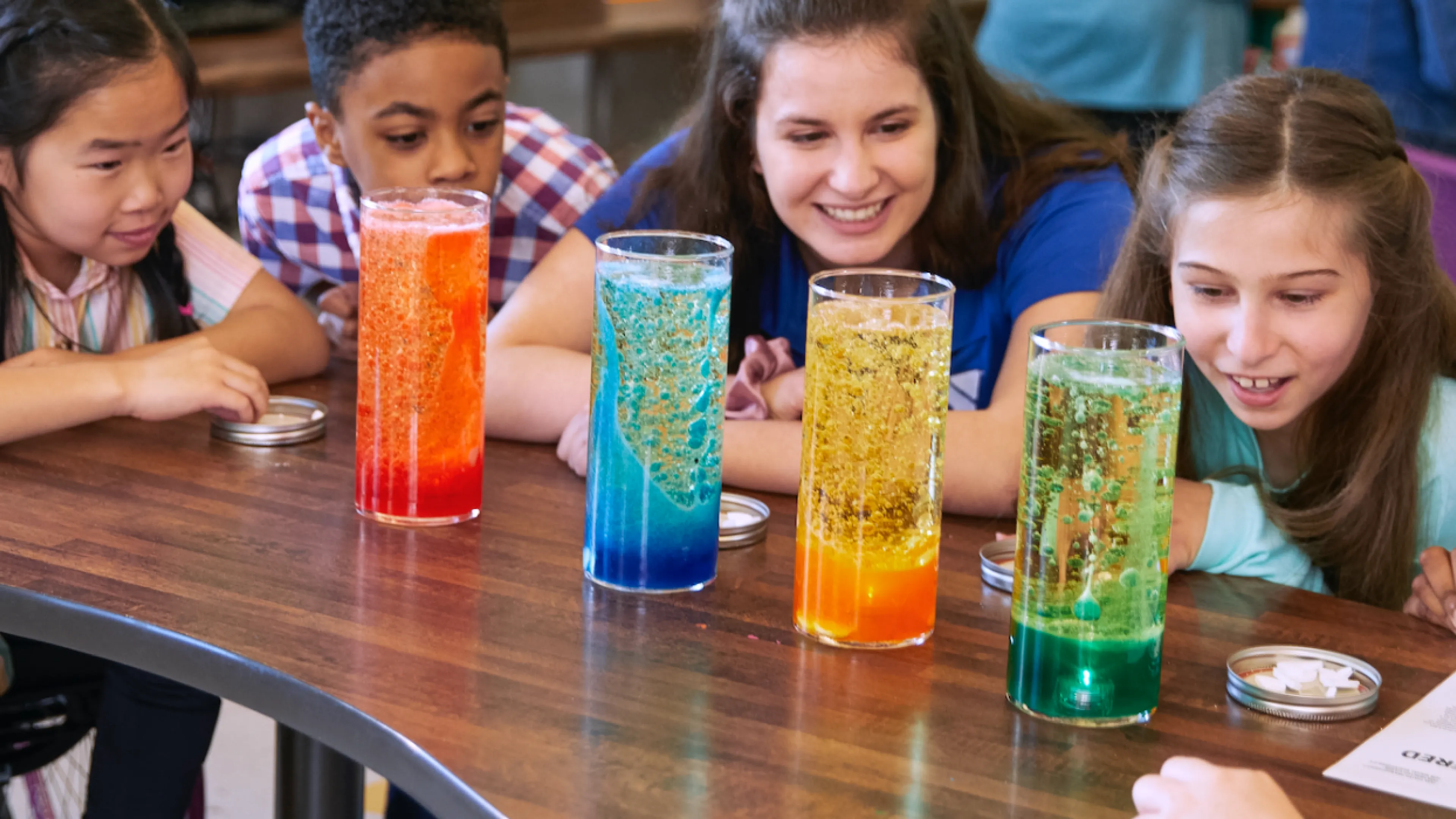 Teacher and students observe colorful science experiment
