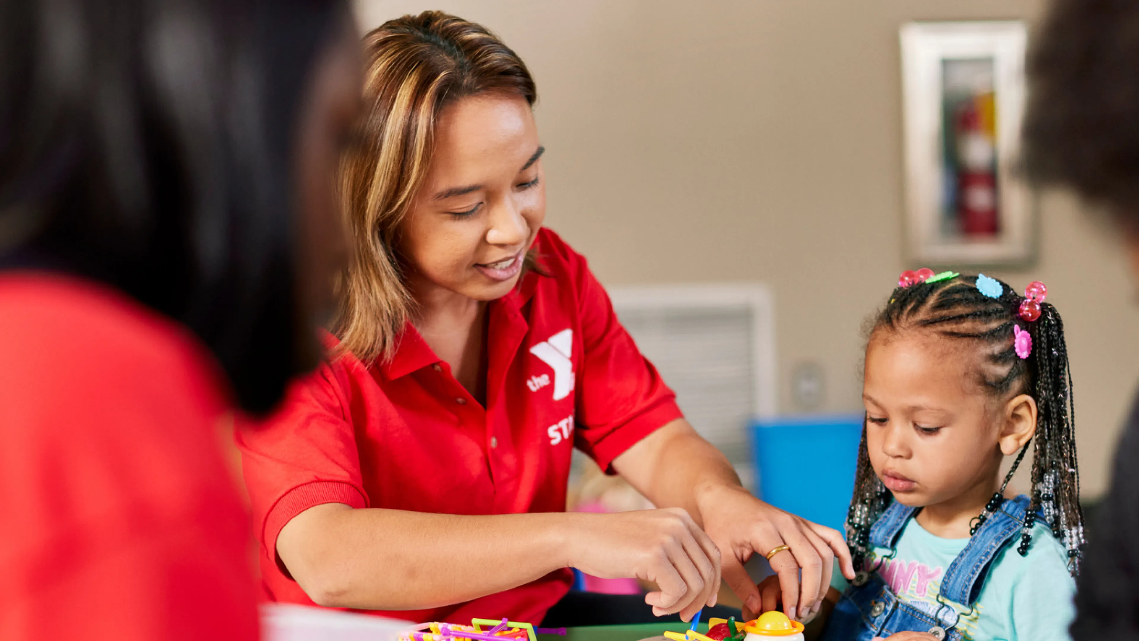 y staff member helping young child