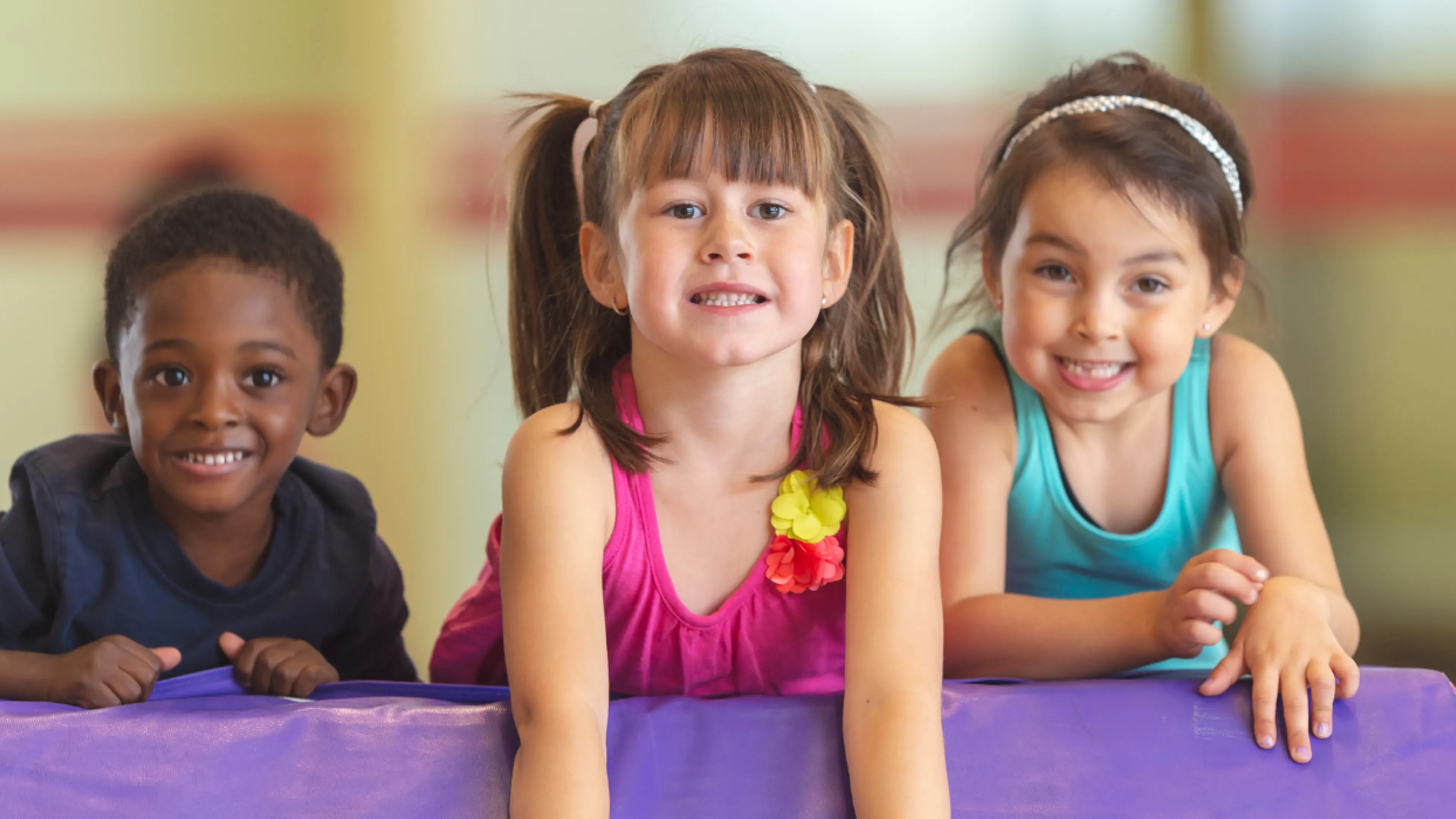 three young kids smiling on obstacle course