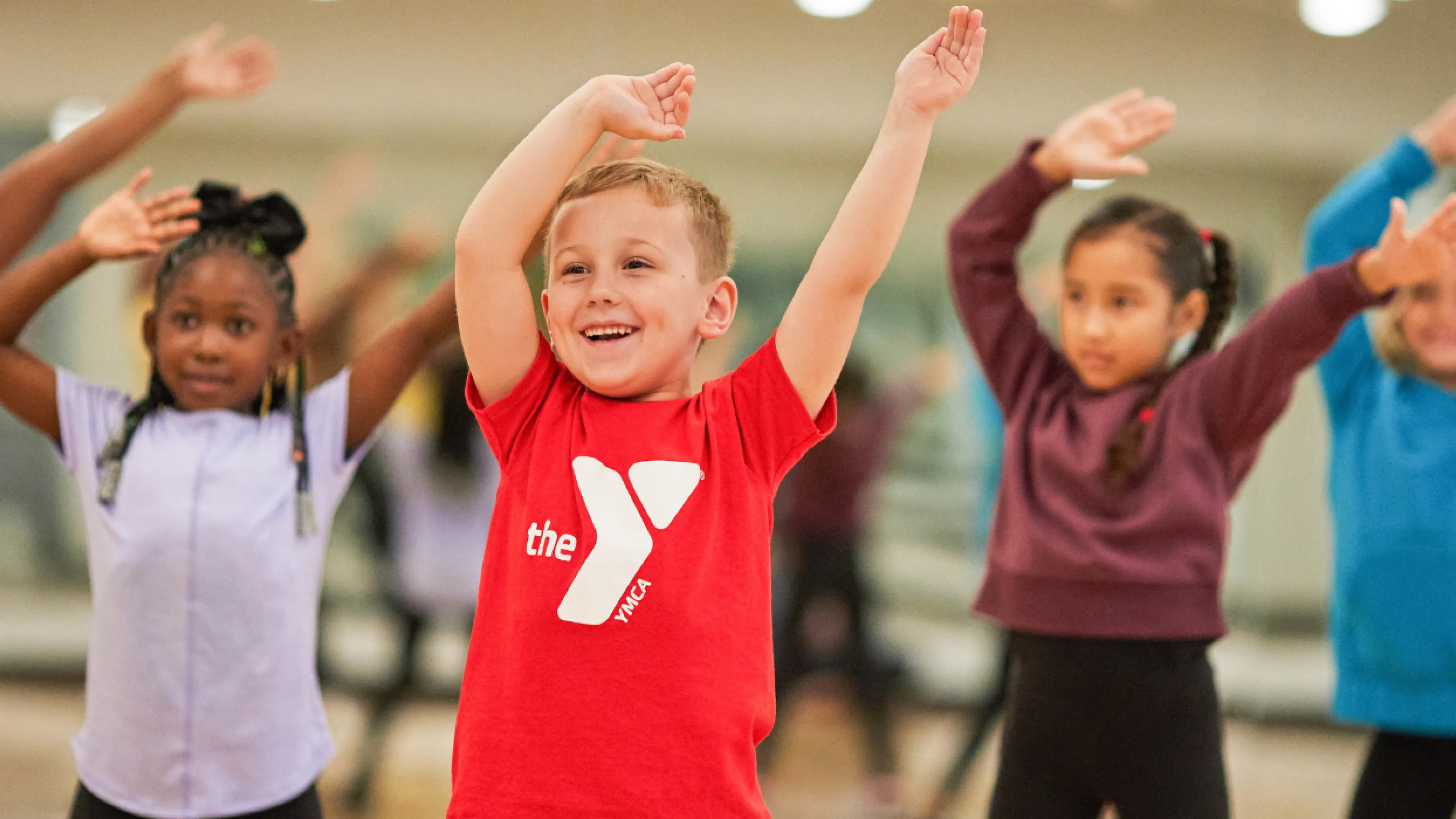 group of young kids smiling with their arms in the air