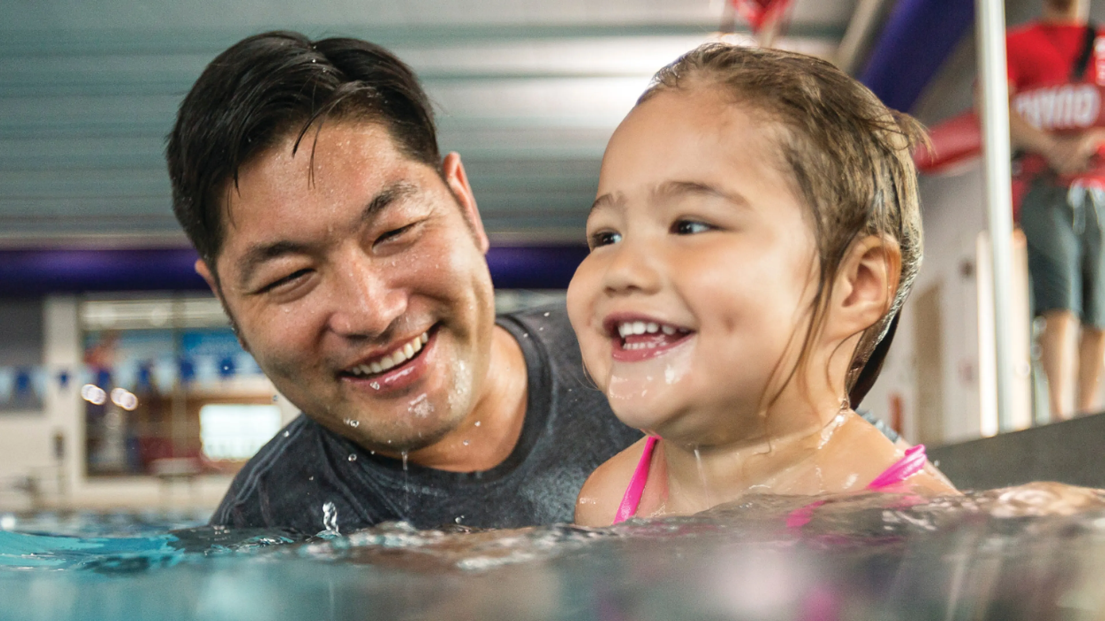 father teaching young daugther how to swim