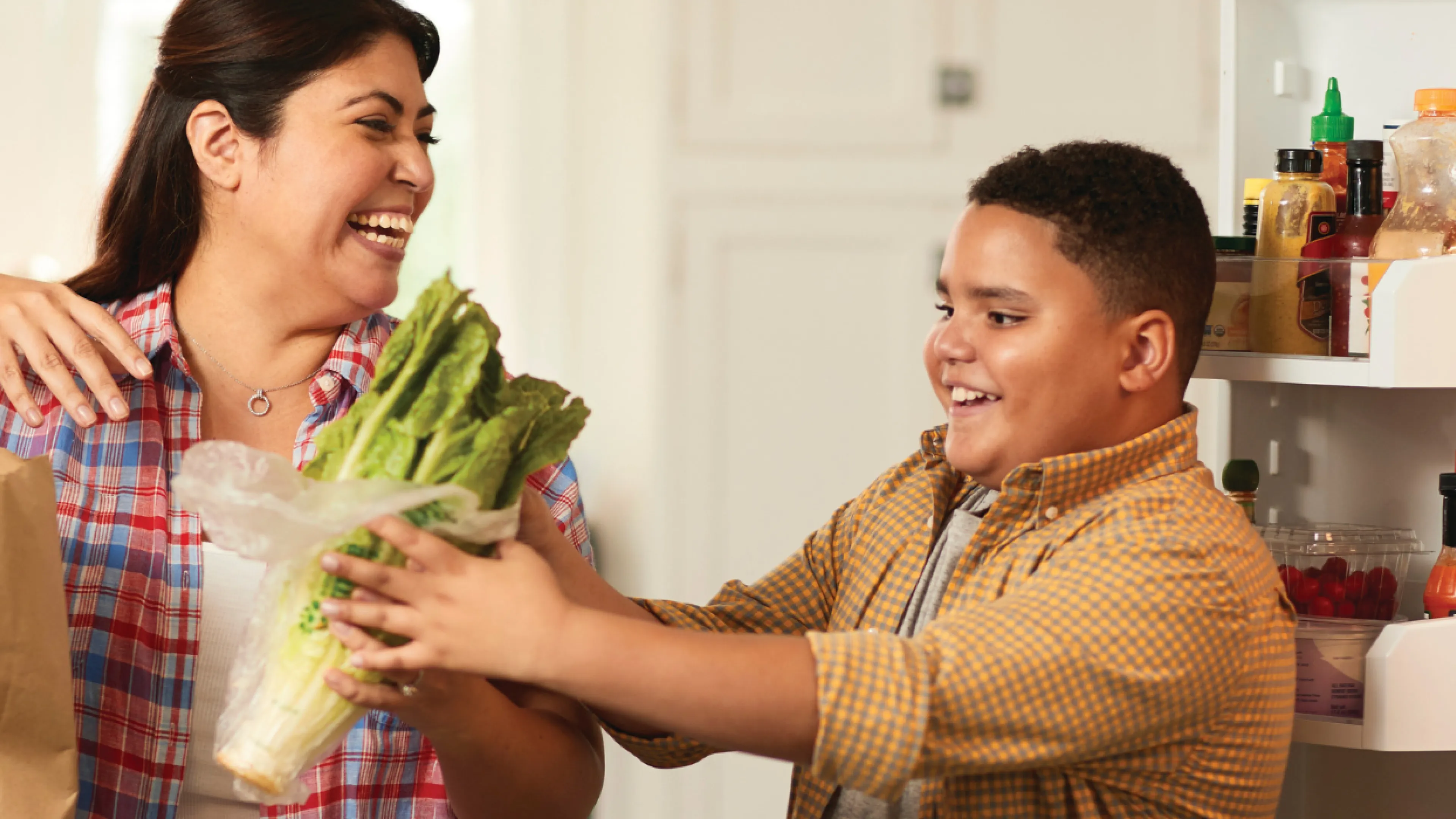 mother and son putting away groceries