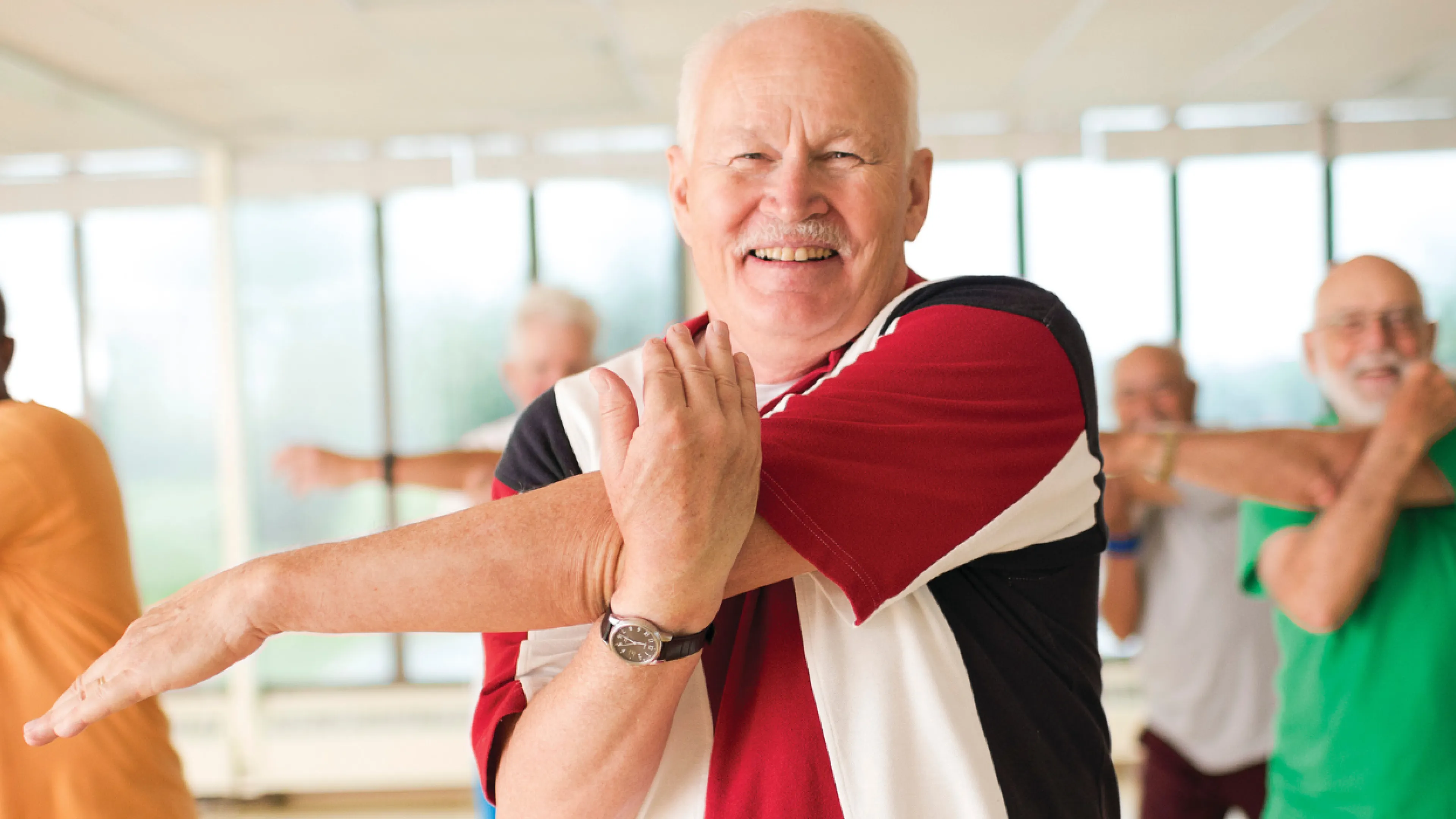 group of seniors stretching in wellness class