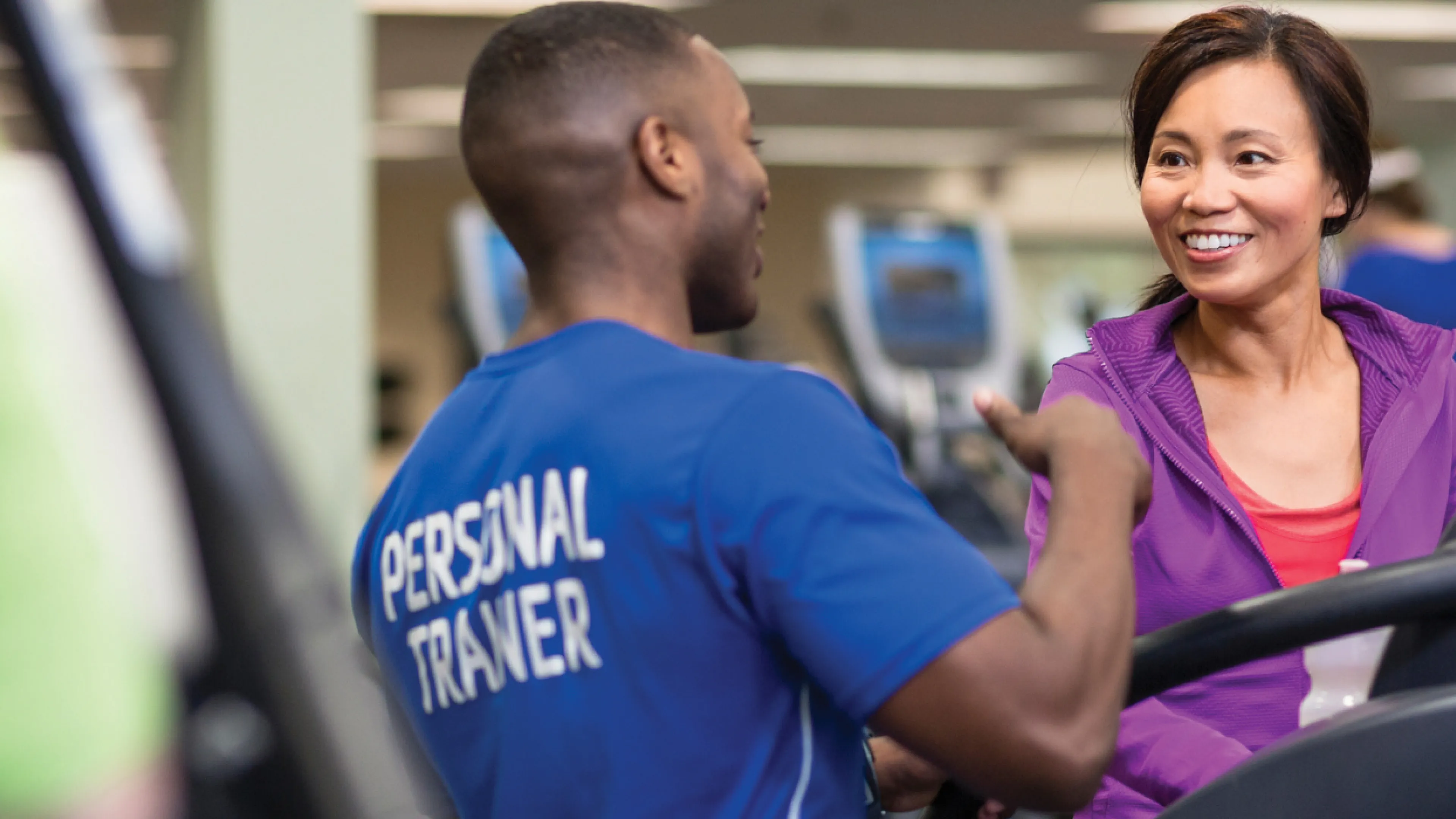 personal trainer working with client on the treadmill