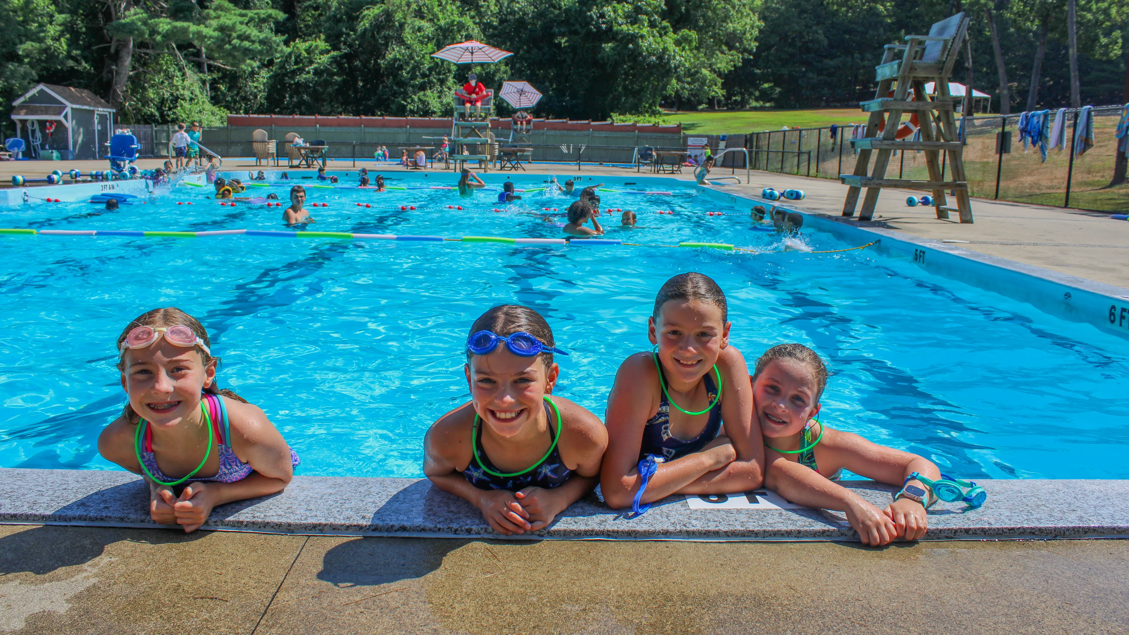 four girls at the edge of a pool