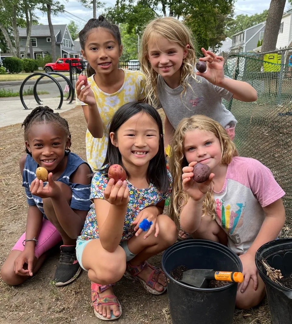 image of a group of young campers holding potatoes
