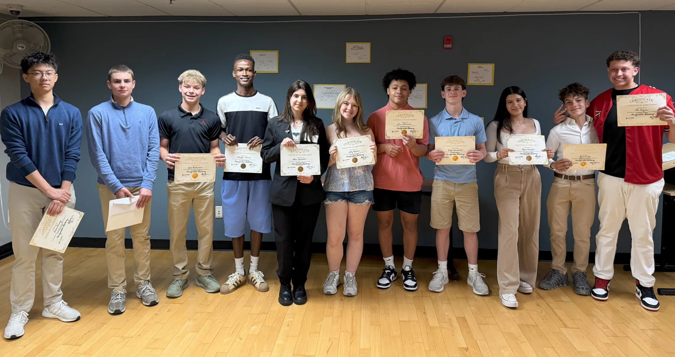 group of teens holding their program certificates and smiling