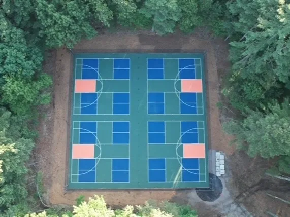 aerial view of outdoor pickleball courts surrounded by trees