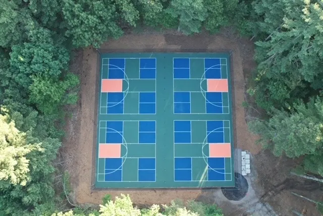aerial view of new pickleball courts surrounded by trees