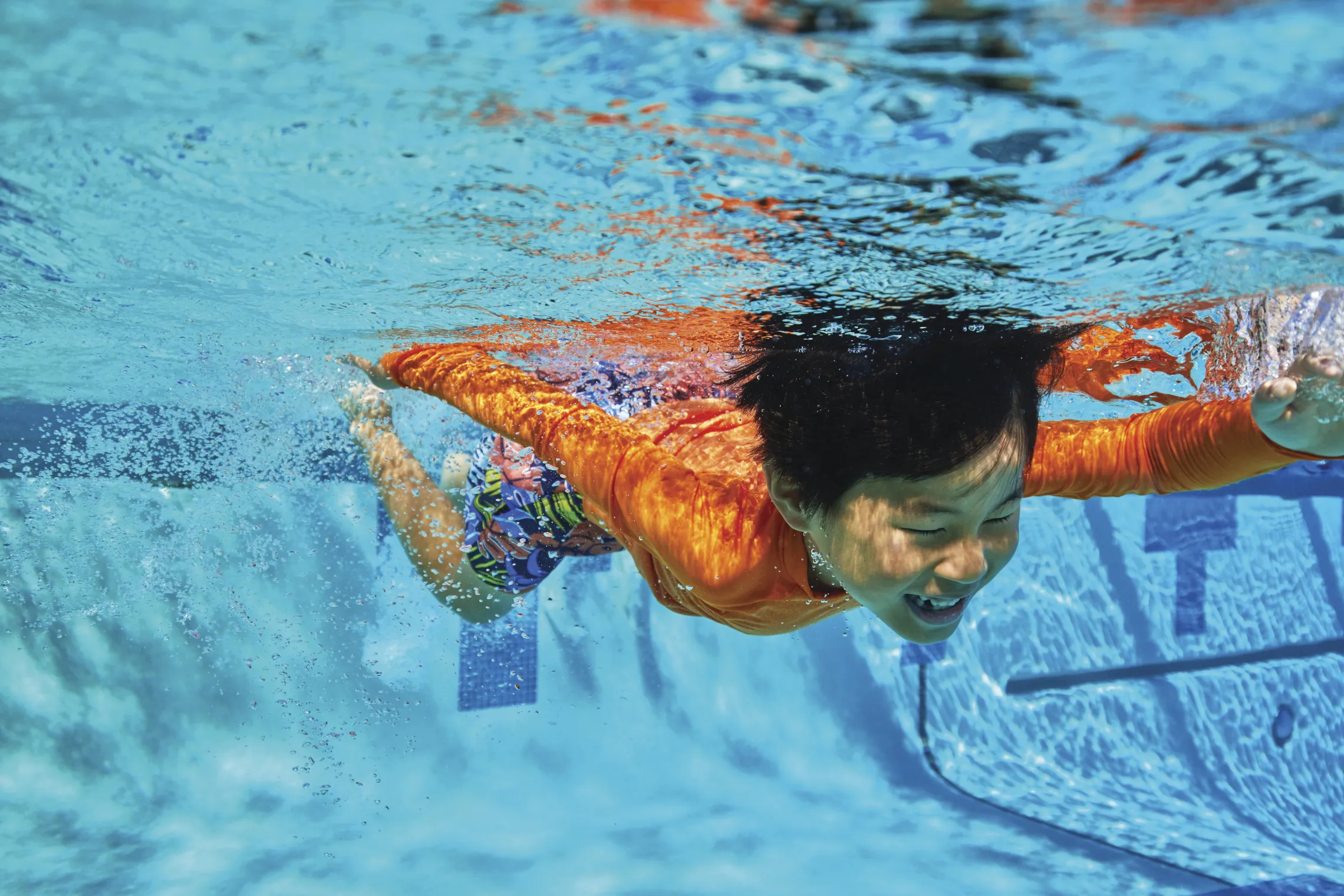 young boy swimming under water