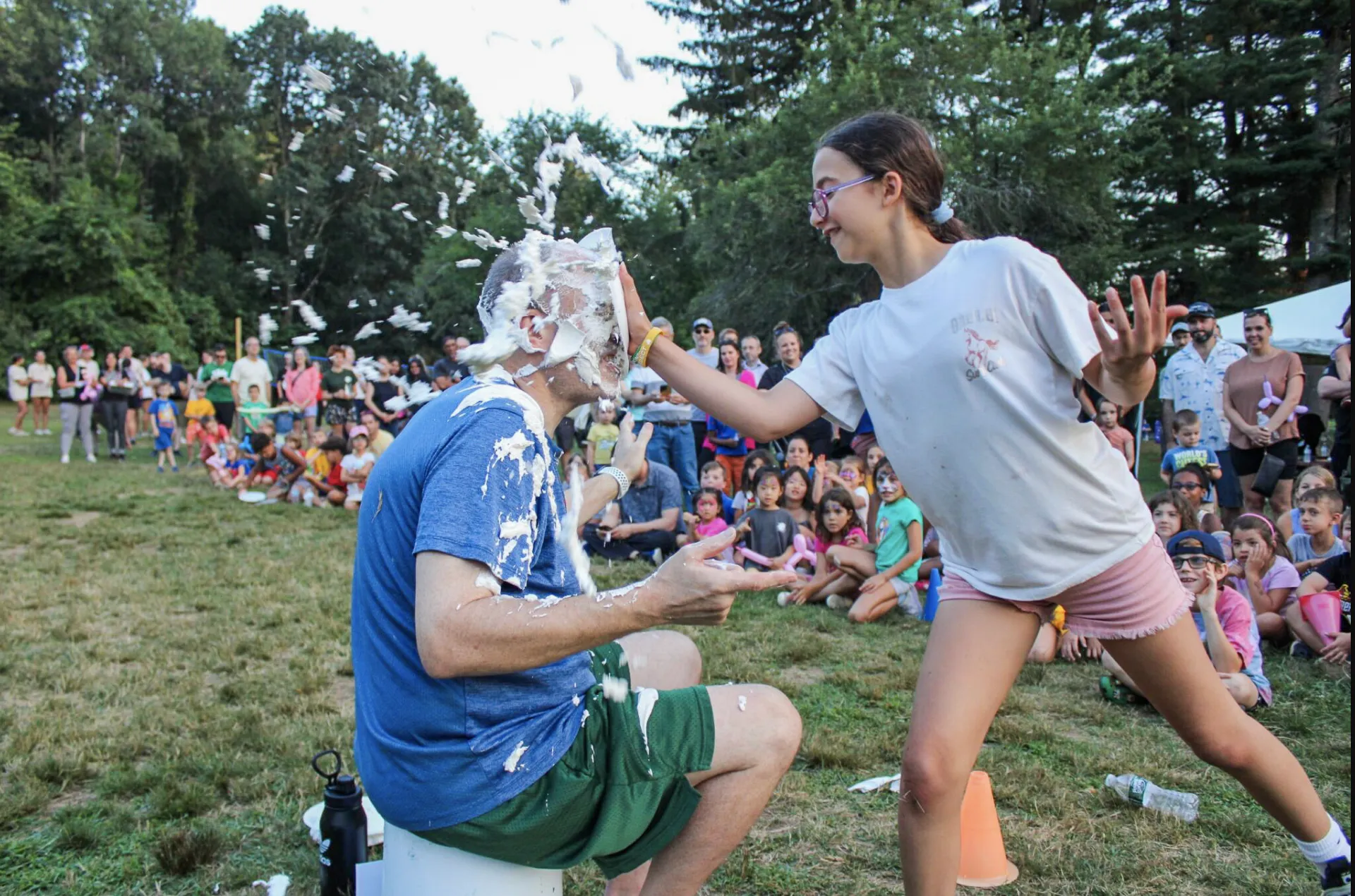 camper pie-ing camp staff member in the face