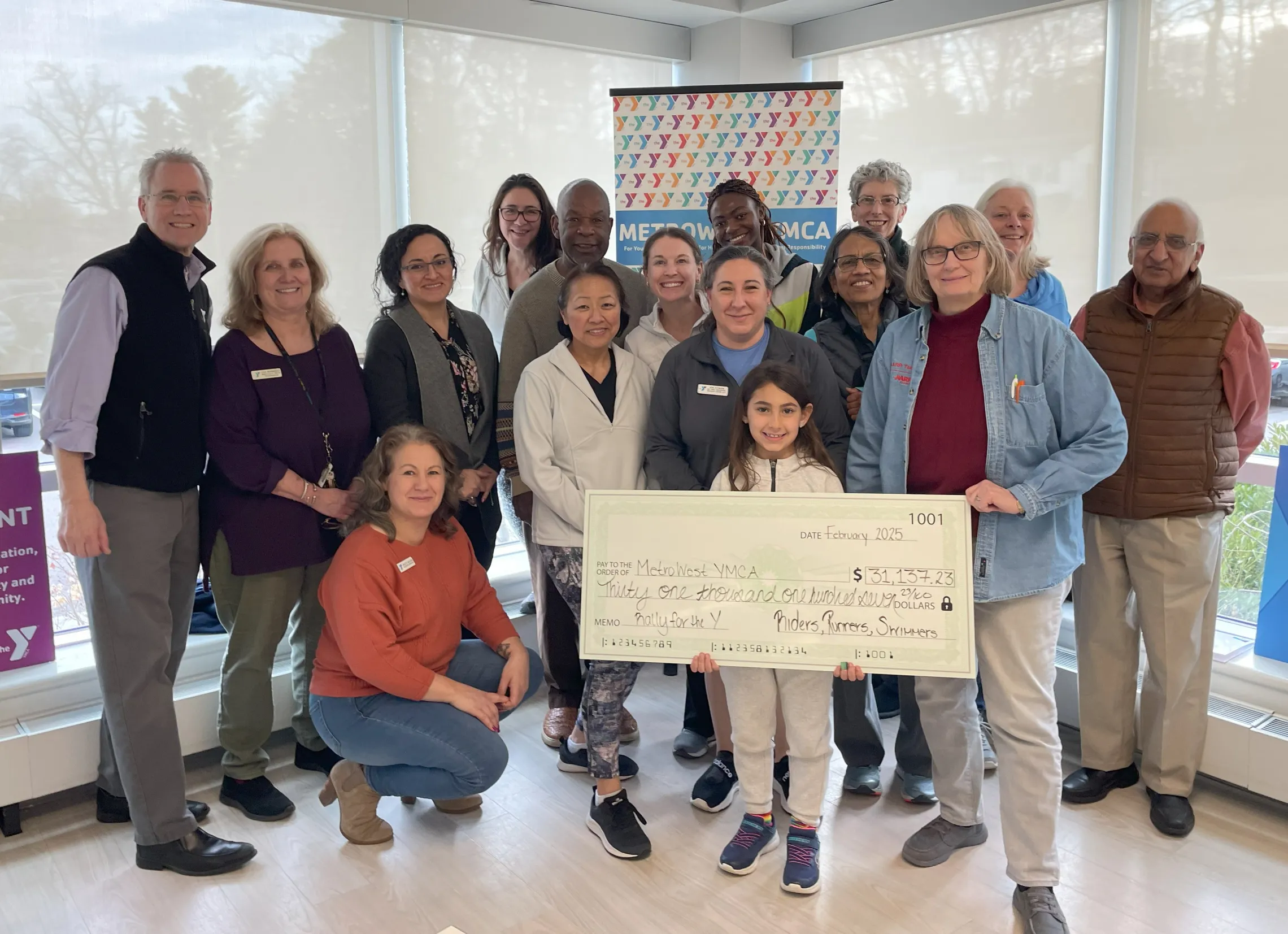 group of YMCA program participants holding a large check