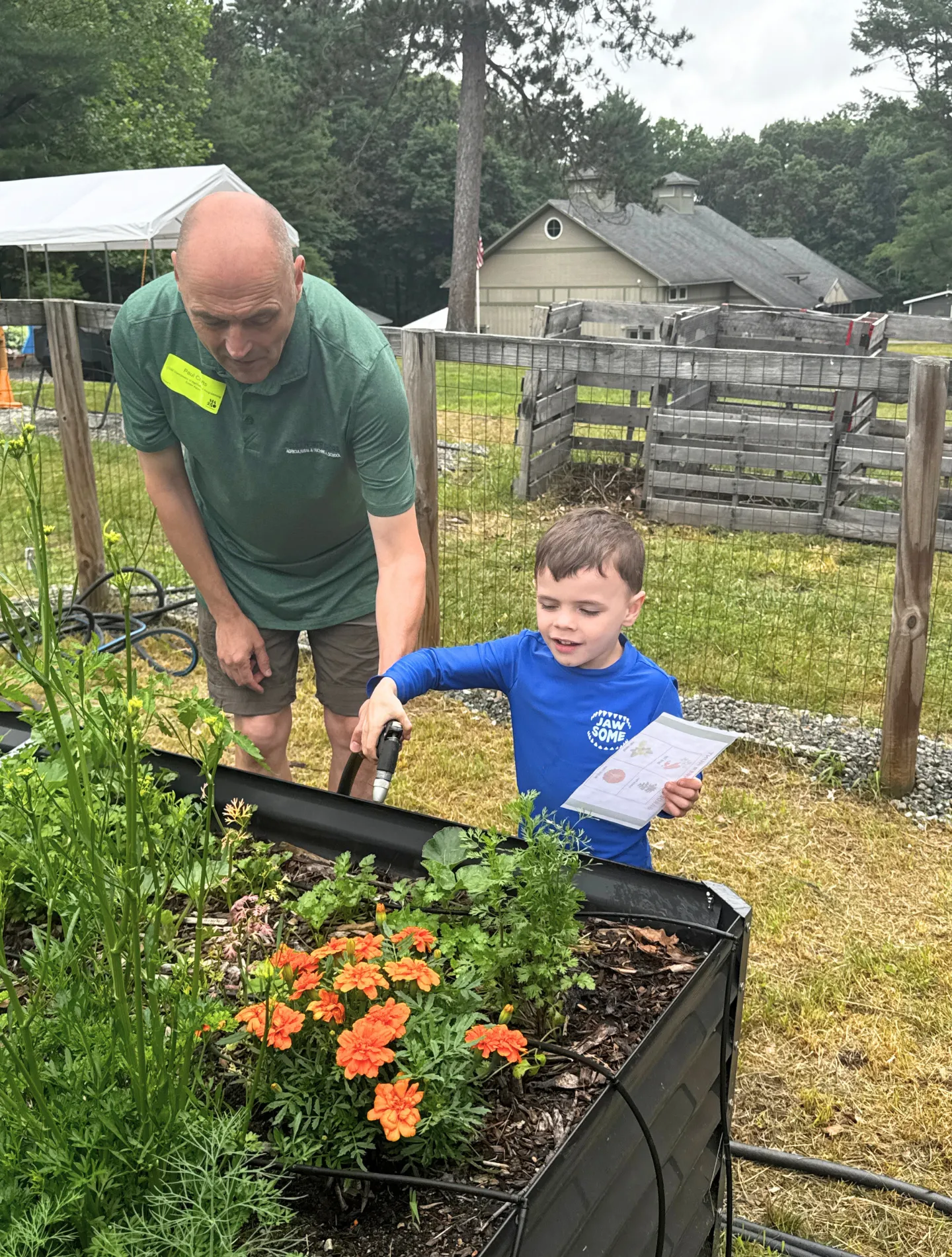 A young summer camper waters the garden at the Outdoor Center