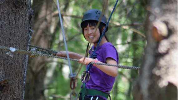 girl smiling on ropes course