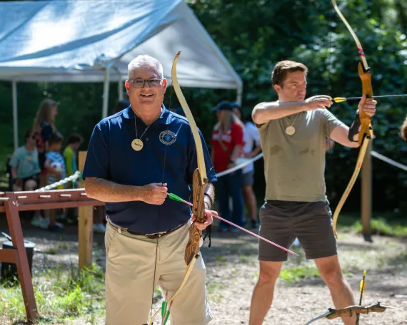 Community leaders attempt archery at the MetroWest YMCA Advocacy Day