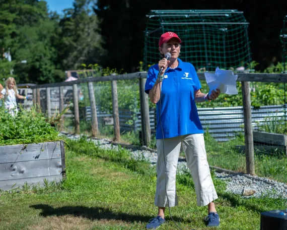 MetroWest YMCA Leader gives a speech on advocacy day in front of the Outdoor Center community garden