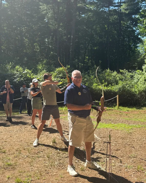 Community leaders attempt archery at the MetroWest YMCA Advocacy Day
