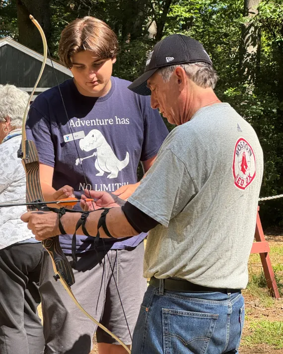 Community leaders attempt archery at the MetroWest YMCA Advocacy Day