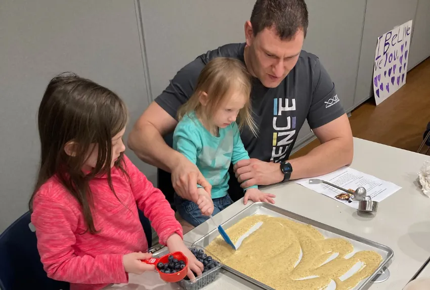 young girls and their dad together at cooking class