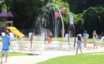 image of kids playing in a splash pad on a sunny day
