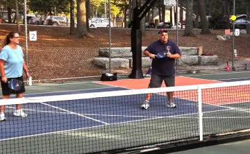 image of two adults playing outdoor pickleball