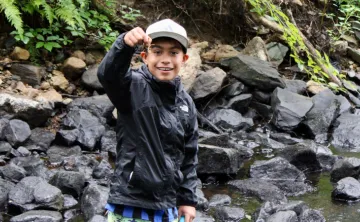boy holding up a crayfish