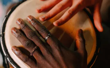 2 hands hitting an African Drum