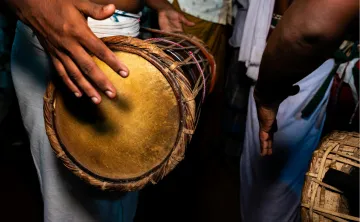 Action shot of someone playing the talking drum