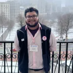 School's Out Director standing on a balcony overlooking a park on a snowy day