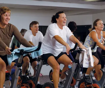 All ages and genders people smiling in spin class