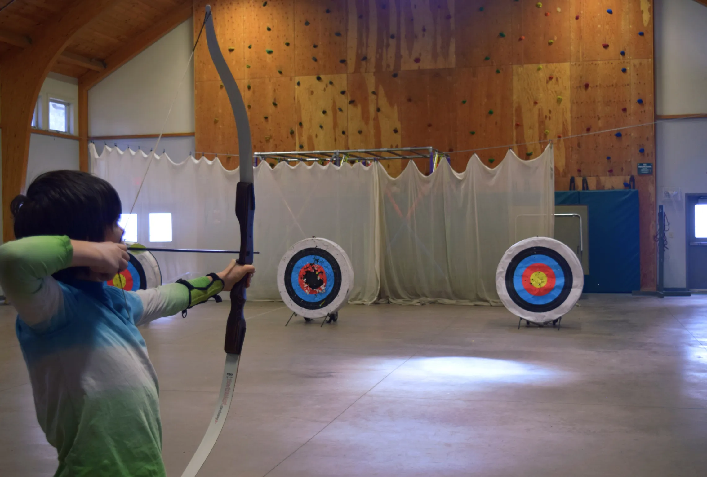 image of boy at indoor archery range