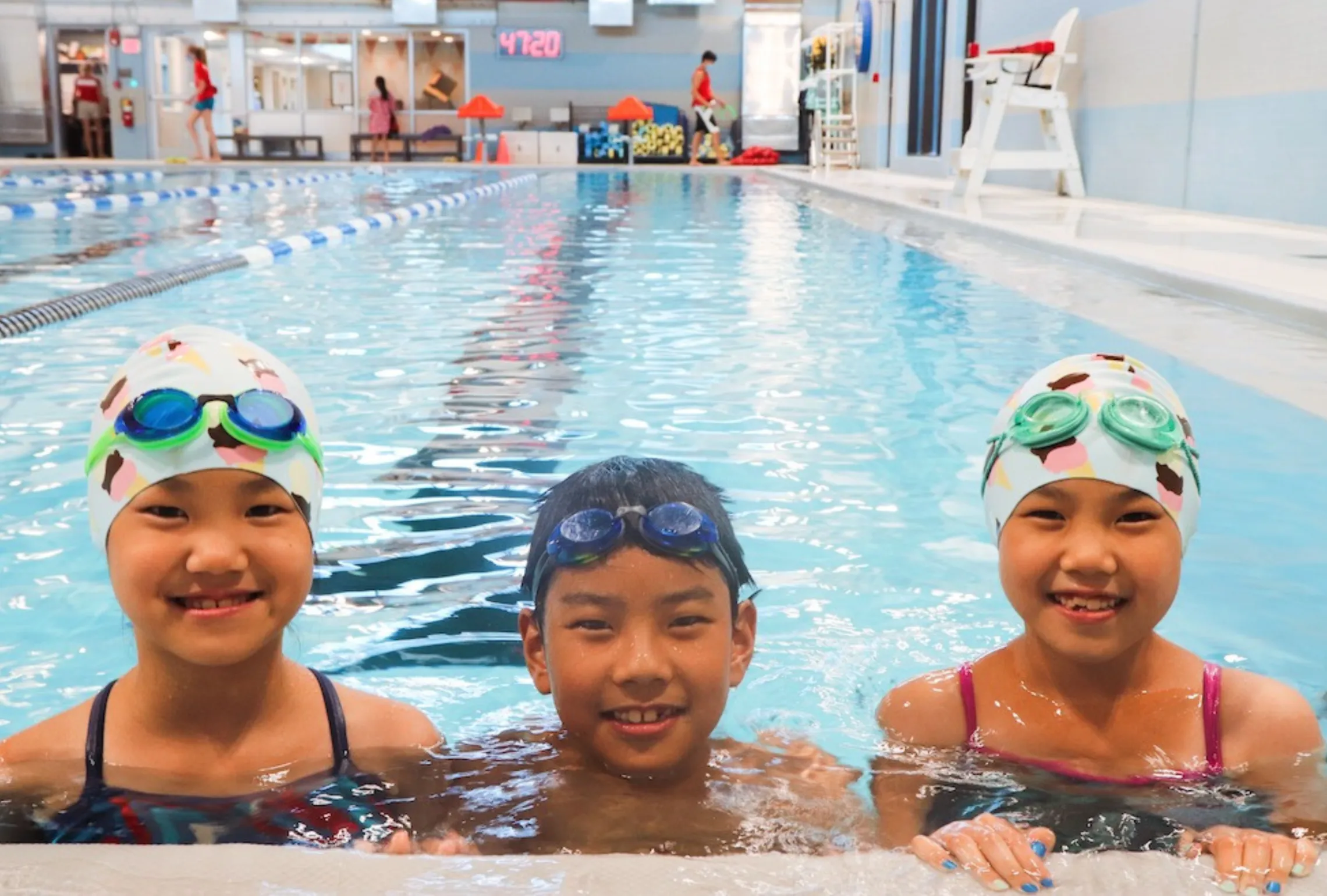 Three youth in the pool smiling